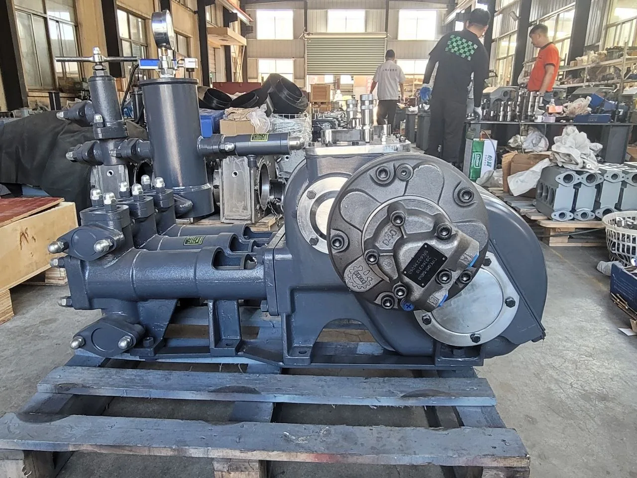 Side view of a reciprocating mud pump photographed at a manufacturing partner workshop
